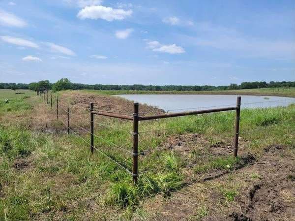 High-tensile wire agricultural fencing around a farm pond